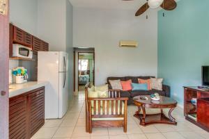 瓜納卡斯特的住宿－Aquamarine 4，厨房以及带沙发和桌子的客厅。