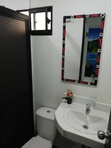 a bathroom with a toilet and a sink and a mirror at APARTA ESTUDIO 7051 in Medellín