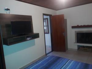 a living room with a flat screen tv on the wall at Chales netuno in Monte Verde