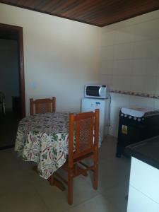 una stanza con tavolo, due sedie e un forno a microonde di Chales netuno a Monte Verde