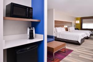 Cette chambre comprend 2 lits et une télévision. dans l'établissement Holiday Inn Express Hotel & Suites Elgin, an IHG Hotel, à Elgin