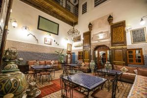 a room with tables and couches in a building at Riad Dar Tahri in Fès