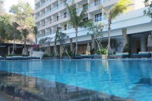 a swimming pool in front of a hotel at Louis Kienne Resort Senggigi in Senggigi
