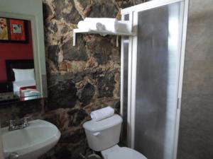 a stone bathroom with a toilet and a sink at Hotel Montroi City in Colima +22 photos