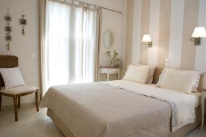a bedroom with a bed and a chair and a window at Kores Villas in Nydri