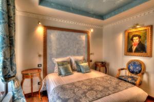 a bedroom with a bed with a painting on the wall at The Originals Boutique, Hôtel Aultia, Ault in Ault +45 photos