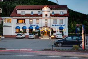 a large building with cars parked in a parking lot at Landhotel Schuff in Kindsbach