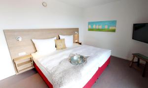 a bedroom with a bed with a bowl on it at Seesichtpur Wohnung Kaiser in Pelzerhaken