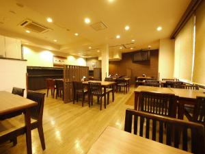 um restaurante com mesas e cadeiras de madeira e mesas e tampo de mesa em Hotel Route-Inn Court Ina em Ina
