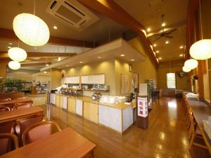 a restaurant with a counter and some tables and chairs at Hotel Route-Inn Court Azumino Toyoshina Ekiminami in Azumino