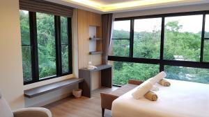a bedroom with large windows and a bed and a couch at Reiz - Private Residence in Chiang Mai