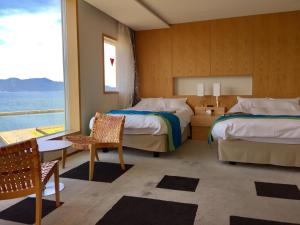 a bedroom with two beds and a view of the ocean at Uminpia in Oi