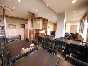 a dining room with tables and chairs in a restaurant at Hotel Route-Inn Myoko Arai in Myoko