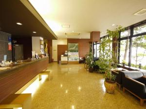 a lobby with a waiting area with potted plants at Hotel Route-Inn Myoko Arai in Myoko