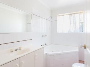 a white bathroom with a sink and a mirror at Haven Waters 6 in Forster