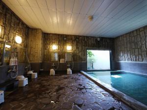baño grande con piscina con 2 urinarios y lavamanos en Hotel Route-Inn Igaueno -Igaichinomiya Inter-, en Iga