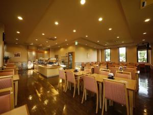 un restaurante con mesas y sillas en una habitación en Hotel Route-Inn Igaueno -Igaichinomiya Inter-, en Iga