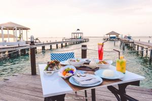 a table with food on it next to the ocean at Kept Bangsaray Hotel Pattaya in Bang Sare