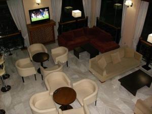 a living room with a couch and chairs and a television at Hotel Pantheon in Pýrgos