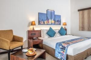 Pokój hotelowy z łóżkiem i krzesłem w obiekcie Amethyst Resort Passikudah w mieście Pasikuda