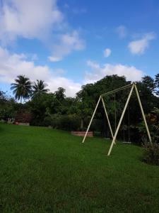 a large swing set in a field of grass at DOMAINE de VALCINE 3 gites parc et piscine à 4 mn de la distillerie DBM, des 1er commerces et de la cascade de BIS in Sainte-Rose