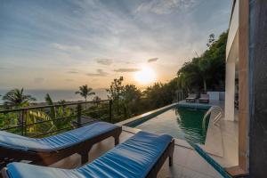 a swimming pool with a view of the sunset at Samui Paradise Village in Nathon