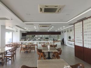 a restaurant with tables and chairs and a counter at Vinh Trung Plaza Hotel in Da Nang