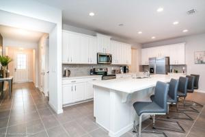 a kitchen with white cabinets and a white counter top at 1719Cvt Orlando Newest Resort Community Home Villa in Orlando