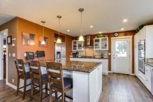 a kitchen with a island with chairs in it at Crystal Rose Home and Cottage in Lincoln City