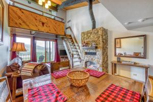 een woonkamer met een tafel en een open haard bij Emerald Views at the West in Steamboat Springs
