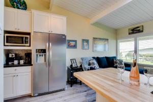 eine Küche mit einem Kühlschrank aus Edelstahl und einem Tisch in der Unterkunft Surfside | Suite on the Sea in Gearhart