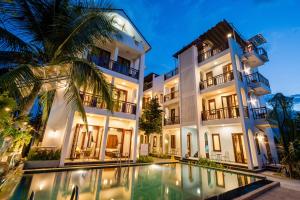 um hotel com piscina em frente a um edifício em Crony Villa - STAY 24H em Hoi An