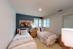 two beds in a room with two windows at Tranquil Family Retreat in Sun Valley