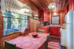 eine rote Küche mit einem Tisch und einem Kühlschrank in der Unterkunft The Cherry Leaf Lodge & Retreat on Fallen Leaf Lake in Fallen Leaf