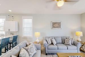 a living room with two couches and a kitchen at Barefoot Cottages #B10 in Highland View
