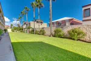 un gran patio con palmeras y una pared en Dolphin #22, en South Padre Island