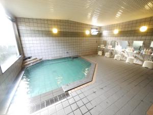 La salle de bains est pourvue de toilettes et d'une grande piscine. dans l'établissement Hotel Route-Inn Court Kashiwazaki, à Kashiwazaki