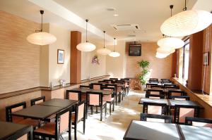 une salle à manger avec des tables, des chaises et des lumières dans l'établissement Hotel Route-Inn Court Kashiwazaki, à Kashiwazaki