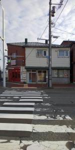 eine leere Straße mit einem Zebrastreifen vor einem Gebäude in der Unterkunft Hakodate station 5minutes walk vacation stay in Hakodate