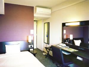 Cette chambre comprend un lit et un bureau avec un ordinateur. dans l'établissement Hotel Route-Inn Ashikaga-2, à Ashikaga