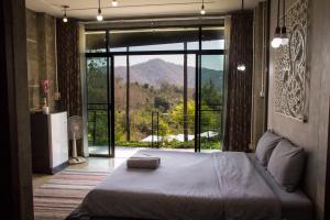 a bedroom with a bed with a view of a mountain at Phu Pha View Doi in Samoeng