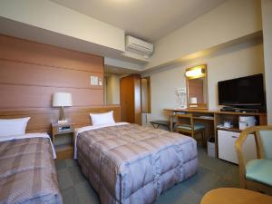 真岡市にあるホテルルートイン真岡のベッド2台、薄型テレビが備わるホテルルームです。