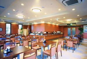 uma sala de jantar com mesas e cadeiras de madeira em Hotel Route-Inn Mooka em Mooka