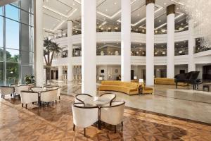 a lobby with a couch and tables and chairs at Wyndham Grand Kayseri in Kayseri