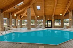 a large swimming pool in a building with a wooden ceiling at Baymont by Wyndham Tuscola in Tuscola