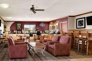 un restaurante con sillas y mesas y un bar en Baymont by Wyndham Golden/Red Rocks, en Lakewood