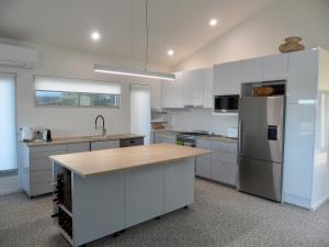 a kitchen with white cabinets and a wooden counter top at WHITE SHELLS HOLIDAY RENTAL in Nepean Bay