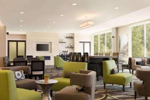 un gran vestíbulo con sillas y un piano en La Quinta Inn & Suites by Wyndham Burlington, en Burlington