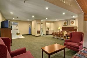 a hotel room with a bed and a living room at Baymont by Wyndham Tuscola in Tuscola