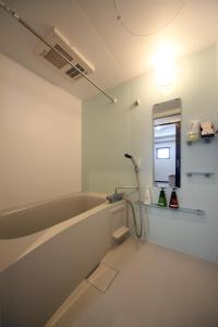 bagno con vasca e specchio di EX Itoman Apartment 701 a Itoman